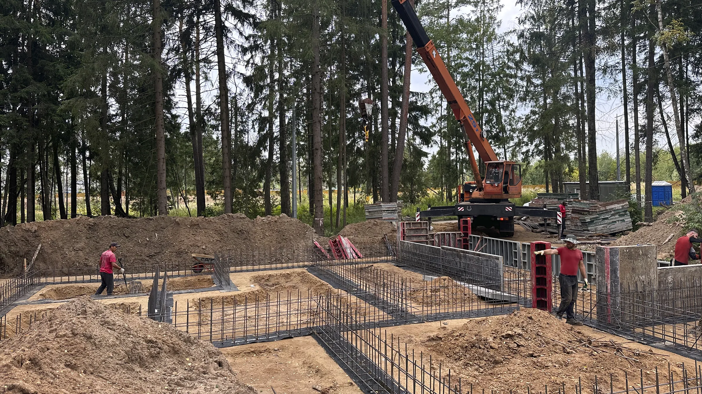 View of the rear and side of a Porsche 911 Turbo S in Oak Green Metallic Neo, standing in a courtyard.
